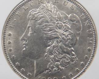 Lot 147. 1900 O Morgan silver dollar. Graded AU 58 by NGC.