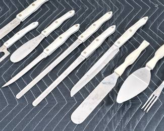 (10pc) CUTCO KNIVES & SERVING UTENSILS | Including an 8” chef knife, these serrated knives, a bagel knife, boning knife, cheese knife, spreader, pie server, and tongs.
