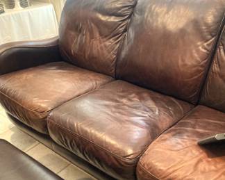 Leather sofa has matching loveseat, chair, and ottoman