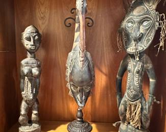 Buyu 21" Carved Wooden Female Figure from Democratic Republic of Congo Shown Beside a Guro People Mask with Rooster Superstructure from the Ivory Coast , 22") and a Feather Adorned 26" PNG Iatmul Ancestral Spirit Painted Wooden Figure with Inlaid Shell Eyes and Twine Skirt.