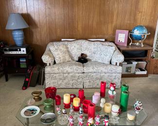 Candles, white floral sofa, lamps, side tables, glass coffee table