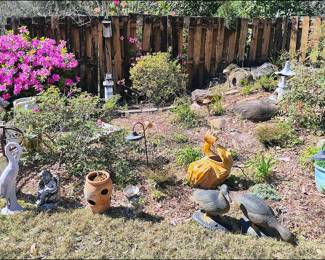 Yard is full of potted plants, fountains and statues