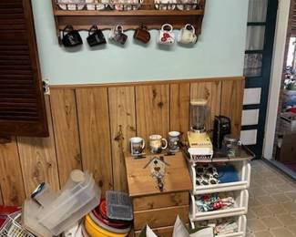 Collector plates.  Solid wood plate and mug rack handmade. Potato bin. Plastic bin storage. Baking sheets. Vintage blender, Can opener. Tupperware. Kitchen and food storage. Thomas Kinkade coffee Mugs.