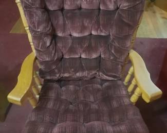 Rocking maroon cushioned chair with ottoman.