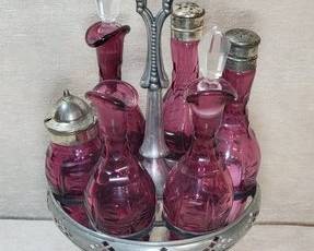 Antique cranberry glass cruet set with holder