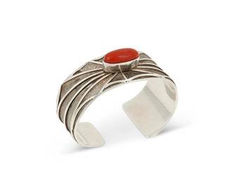 219
A Southwest sterling silver and coral cuff bracelet
Late 20th century
Stamped: DC / W/Yellowhorse / Sterling / USA
A cast silver cuff with spider-web overlay motif surrounding an oval coral cabochon, with tapered terminals
6.125" total inner C x 0.875" H, with a 0.875" gap
59.1 grams gross
Estimate: $600 - $900