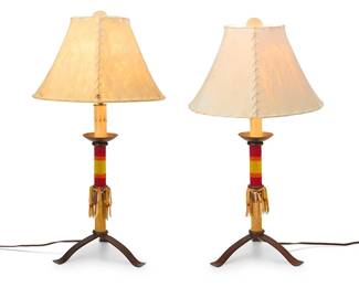 82
A pair of Southwest-style beaded table lamps
Late 20th century
Each marked to underside: Mexico
The single-light wrought-iron lamps, each with a faux candle element above a hide and bead-wrapped standard raised on a tripod base and surmounted by a hide shade, electrified
2 pieces
Each overall: 26" H x 14.25" Dia.
Estimate: $300 - $500