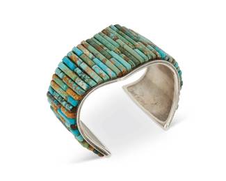 215
A Southwest sterling silver and turquoise cuff bracelet
Late 20th/21st century
Etched to terminal interior: Tew_ Cla_ [illegible]
A heavy cuff with pointed shaped edges and multiple rows of variegated turquoise sculptural cobblestone inlay
7.125" total inner C x 2" H, with a 1.5 " gap
128.4 grams gross
Estimate: $500 - $700
