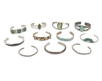 343
A large group of Southwest-style silver cuff bracelets
Late 20th century
Variously marked for sterling and two for maker: L. L Lee / Larry & Idella Bellson / Zuni
Comprising a Larson L. Lee (b. 20th century, Diné) Navajo sterling silver cuff with black stone and purple stone channel mosaic inlay, a Larry & Idella Bellson (b. 20th century, Zuni) single wire cuff with cluster set turquoise, as well as five further cuffs in various styles and sizes with set turquoise and greens stone, including cluster set, bezel set and inlay, together with a mixed metal and silver cuff with ornate floral and filigree overlay, and three further silver cuffs with silver ball banding, two marked sterling, 11 pieces
Largest; 6.625" total inner C x 0.375" H, with a 1" gap; smallest: 5.625" total inner C x 0.125" H, with a 1" gap
197.3 grams gross
Estimate: $300 - $500