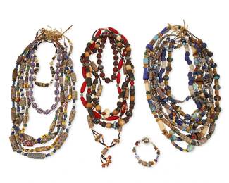 315
A large group of trade beads and necklaces
Late 19th century and later
Comprising a single stand of blue and white glass chunky trade beads, as well as multiple single
strands of yellow, brown, green, grey, blue, red, and white multicolored trade and various multicolored glass, millefiori and other style beads, including a chunky red glass bead and green striped glass bead necklace, and a short red melon-style glass bead necklace with silver spacers, and a multicolored bead bracelet, 19 pieces
Largest: 37" L; smallest: 15.5" L; bracelet: 8.5" L
2312.8 grams gross
Estimate: $100 - $200