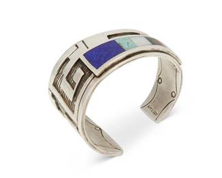 217
A Terrance and Dorothy Emery Ojibway/Jemez silver and stone inlay cuff bracelet
Terrance Emery (1954-2012, St. Croix Ojibway) & Dorothy Emery (b. 20th century, Jemez Pueblo)
Late 20th century
Stamped: D/T Emery
An elegant tapered asymmetrical cuff with silver overlay Pueblo stepped motifs, and a tapered row of graduated stone inlay including lapis, turquoise, opal, onyx, and coral
6.5" total inner C x 1.5" H., with 1" gap
87.3 grams gross
Estimate: $400 - $600