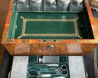 Burlwood box with travel toiletry items fitted interior.