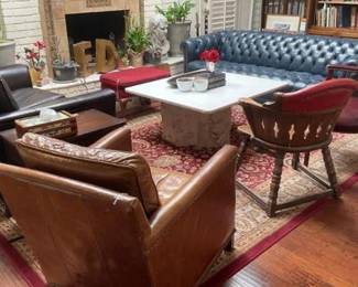 Classic, sophisticated style living room furniture, marble top coffee table, large deep button tufted chesterfield sofa in blue leather. Traditional wooden armchair with curved red leather backrest. 