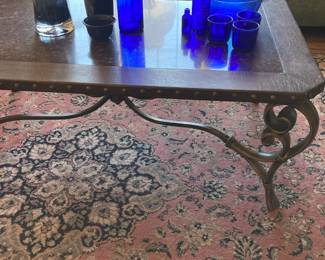 Glass top coffee table with iron base, area rug