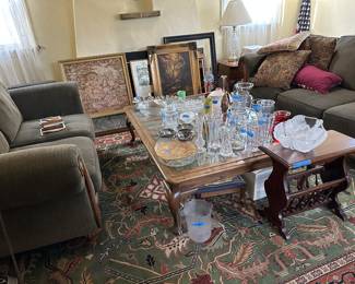 Lots of crystal & glass vases and serving bowls/ plates! A lovely side table w/ magazine rack. Green sofa set. Embroidered artwork, LA Olympics poster, paintings, and frames!