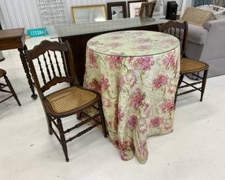 covered round table and 2 small mahogany cane seat chairs