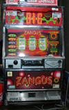 Zangus I Pachislo Machine is a Japanese skill-stop slot machine. It is similar to traditional (auto-stop) slot machines, except with Pachislo, the player uses three buttons to stop the reels, which requires some skill. The machine accepts tokens and features an LCD screen, music and extra reels, which enhances the standard reel play. The spin knob on a Pachislo machine is located on the front of the cabinet – instead of a handle on the side on a traditional slot machine.