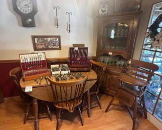 Kling Solid Maple Drop Leaf Table, 2 Leaves, 8 Chairs; St. John’s Table Company Corner Hutch; Anchor Hocking Wexford Glassware; Birdhouse Cookie Jar; Indiana Glass Clear Diamond Point Goblets; Silver Plated and Stainless Steel Flatware; Winchester Wall Clock; Wall Sconces