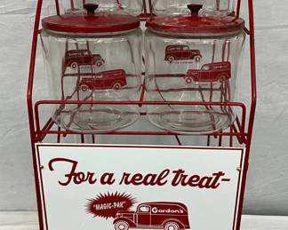 Gordon’s Red Wire Display Rack with Four Glass Jars and a Contemporary Sign