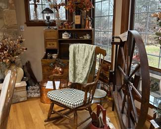 Large spinning wheel and rocking chair.