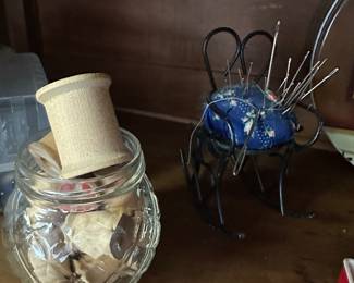 The clear jars filled with vintage wooden spoons and an ice pin cushion