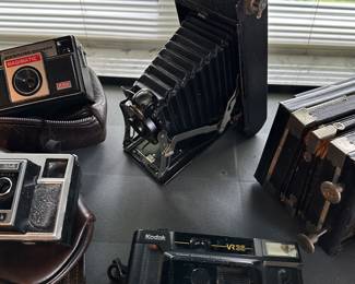 The Vinatge camera at the center is a Kodak No.1 Pocket Folding Camera!
