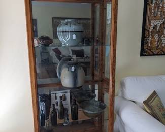 MIRROR BACKED OAK DISPLAY CASE WITH KEY LOCK SIDE DOORS AND TOUCH CONTROL LIGHT SWITCH.