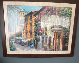 This image is a print of "Village Hideway" by Howard Behrens, know for his textured, colorful paintings. It depicts a quaint European village scene, possibly in Italy, with vibrant blds and lush greenery.