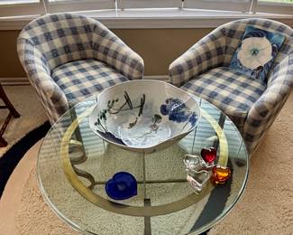 Pair of club chairs on rollers and brass and glass coffee table