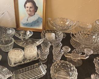 Antique Fostoria and a hand tinted portrait . We’ve been calling her MeMaw Mimi . Her back story is : She was known for her amazing homemade biscuits. She was known for to drink a little and was a hoot! ( client bought it for the frame. No relation) . 