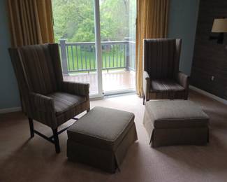Pair of matching upholstered wingback chairs with ottomans beige