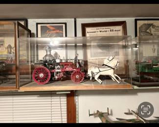 Horse drawn wagon under glass case for auction let’s go.