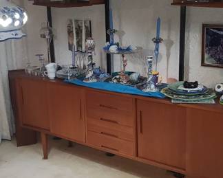 Each glass-front Teak cabinet is 27 1/4" wide x 8" deep. The accent lip at the bottom spans 28 3/8" wide