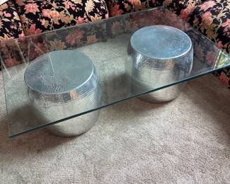 Glass coffee table with hammered silver metal drums