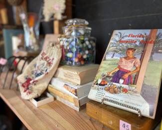 Vintage cookbooks and a large jar of vintage marbles