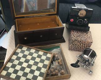 Reuge 4 song music box, stone chess set, Polaroid SX-70 Land camera (Model 2), Pflueger Rocket 1375 reel