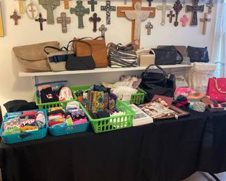 Music boxes on top shelf. Crosses, Purses on shelf. On table, socks scarves, hankies, misc