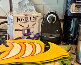Kitchen items including placemats, fondue set, Nespresso, Cuisinart coffee maker