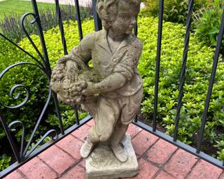 Cement statuary of boy holding basket