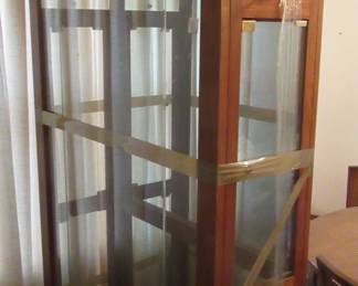 Display with glass shelves, just out of storage and is still wrapped in plastic.