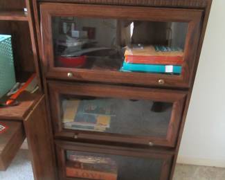 3 door book case with glass fold up doors. Located in office (bedroom 3)