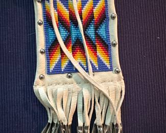 White deer skin beaded medicine bag with tin cones on fringe ends