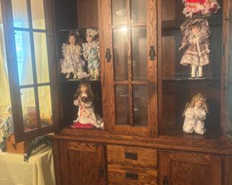 Beautiful wood cabinet. Lots of porcelain dolls