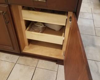 Kitchen island cabinetry has pull out shelves