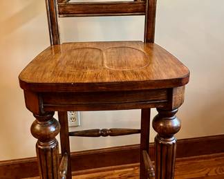 One of four available bar height bar stools with backs.