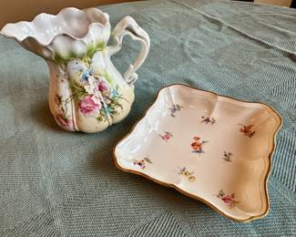 A pink and blue floral designed creamer along side Meissen square porcelain dish.