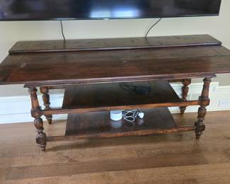 Fold out multi-use table. As a console, can be stored against wall. Fold out one side for use as desk/table. fold out both sides to use as table for up to six persons. Two lower shelves for storage.