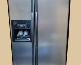 Whirlpool side-by-side refrigerator freezer. Note: This refrigerator freezer in a storage room. The one in the kitchen is not for sale.