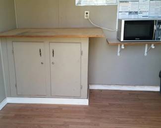 Inside the office is a microwave oven and cabinet with drafting board top.
