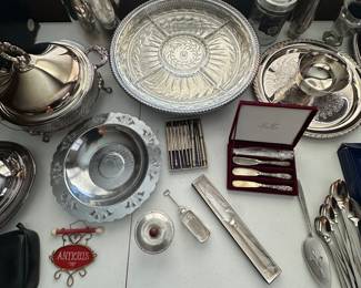 A table filled with assorted silver plate serving pieces! 